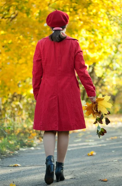 Гуляющая женщина в осеннем парке — стоковое фото