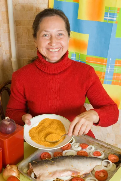Donna sta cucinando pesce arrosto — Foto Stock