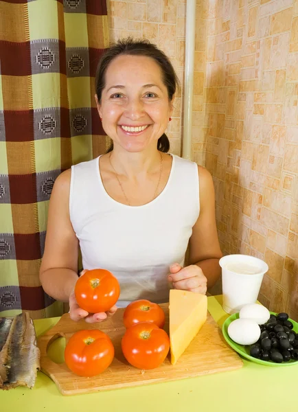 Vrouw met ingrediënten voor gevulde tomatensalade — Stockfoto