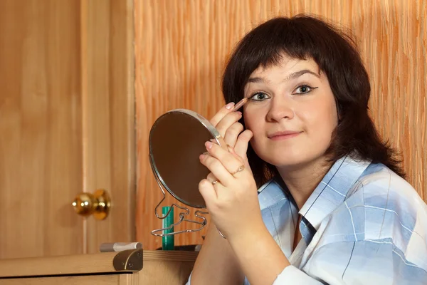 Woman putting make up — Stok fotoğraf