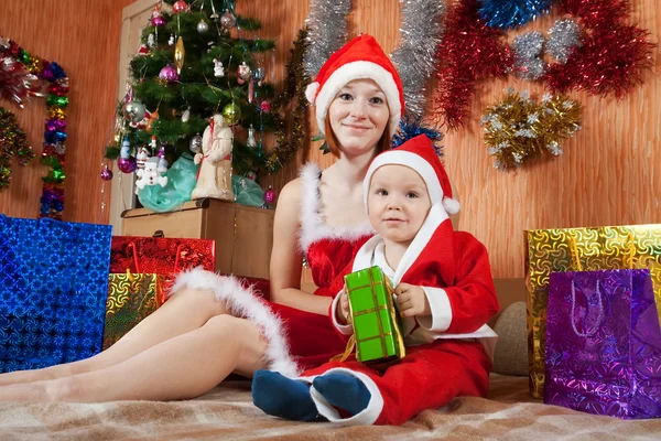 Mulher e menino vestidos como Papai Noel Fotografias De Stock Royalty-Free
