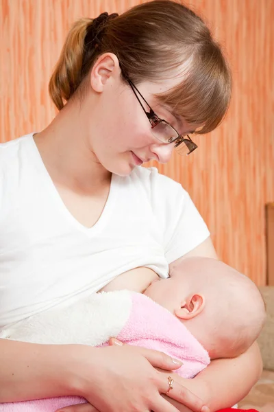 Matka se dívá na dítě sání prsu — Stock fotografie
