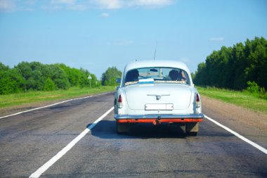 Vintage car on a countryside road clipart