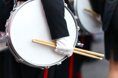 Drum with a hand and drumsticks on parade clipart