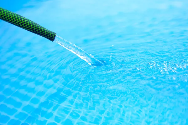 Water is poured from the hose into the pool — Stock Photo, Image