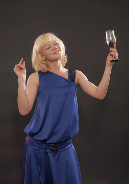 Красива блондинка з келихом вина на чорному тлі — стокове фото