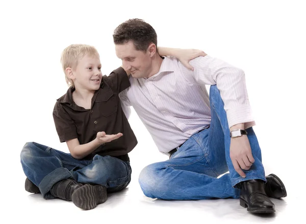 Мальчик и мужчина сидят обнявшись — стоковое фото
