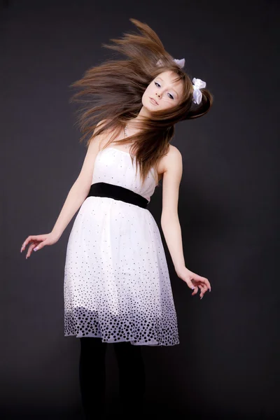 Das Mädchen in einem weißen Kleid auf schwarzem Hintergrund — Stockfoto