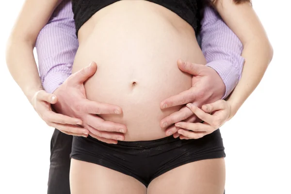 Mans händer omfamna en mage av gravid kvinna — Stockfoto
