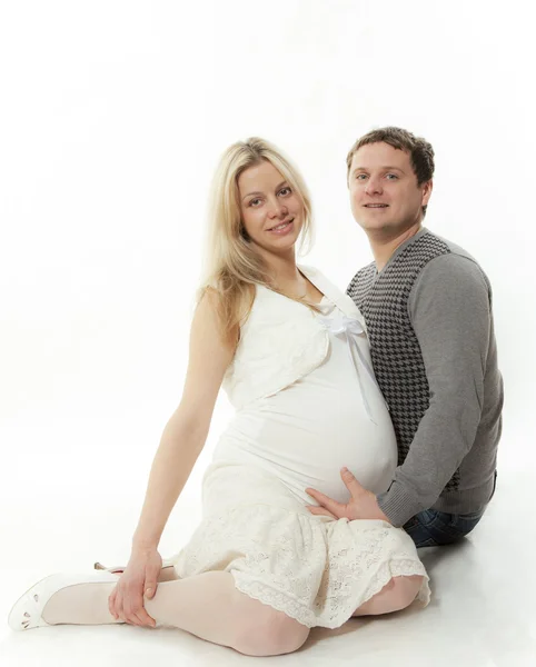 Hamile kadın ve adam beyaz bir arka plan üzerinde oturmak — Stok fotoğraf