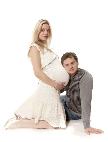 La mujer embarazada y el hombre se sientan sobre un fondo blanco —  Fotos de Stock