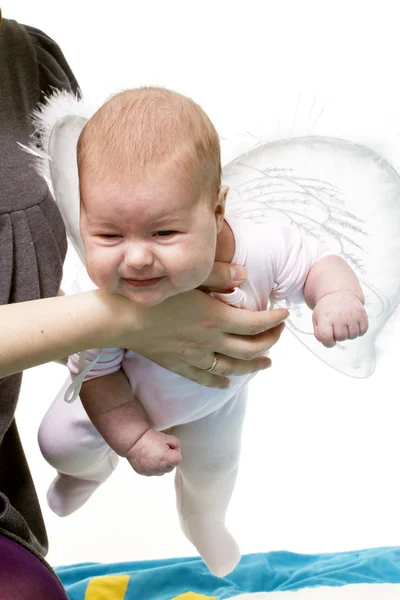 Руки держат новорожденного с крылом — стоковое фото