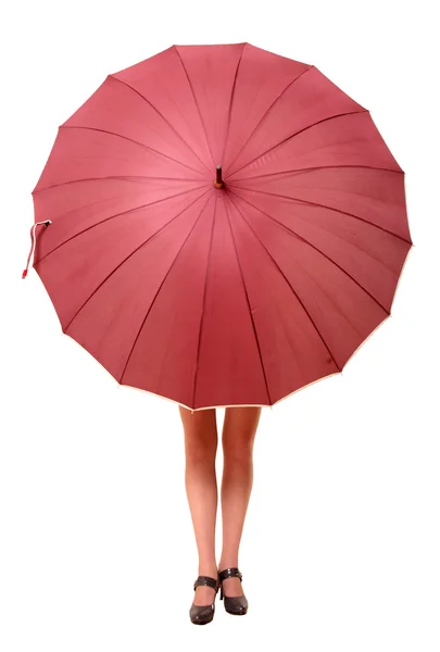 Das Mädchen versteckt sich hinter dem großen Regenschirm, unter dem nur die Füße hervorstehen — Stockfoto