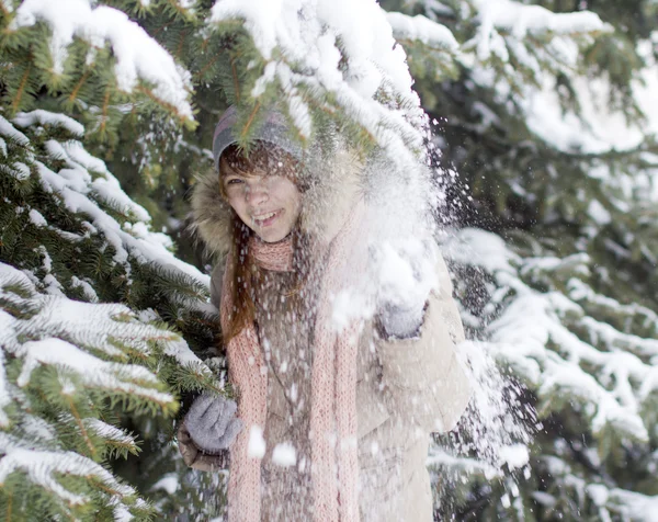 Na dívku ze stromu padá sníh — Stock fotografie