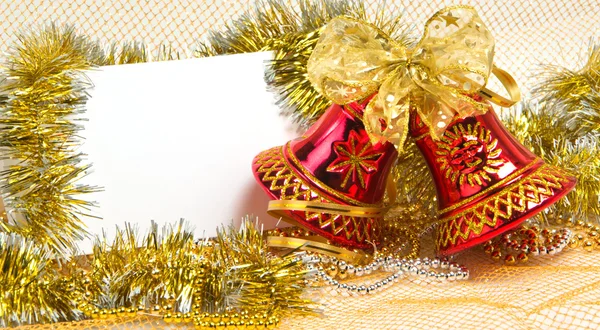 Christmas bells with tinsel and postcard — Stock Photo, Image