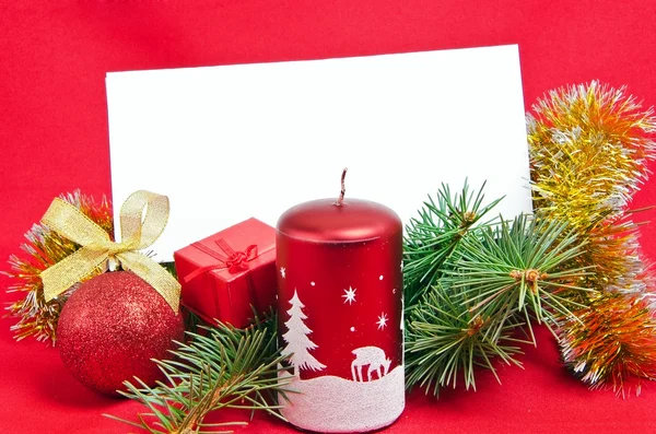 Christmas decorations with card on red — Stock Photo, Image