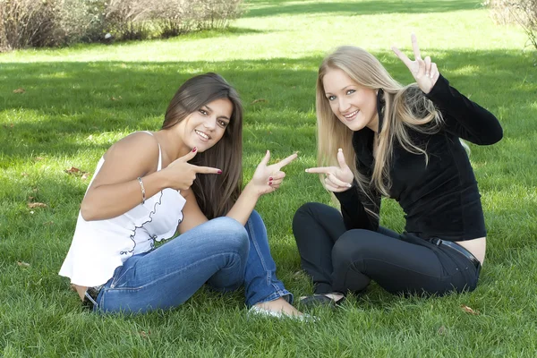 Twee meisjes zitten op gras — Stockfoto
