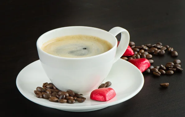 Šálek kávy a srdce formoval čokoládové bonbóny — Stock fotografie