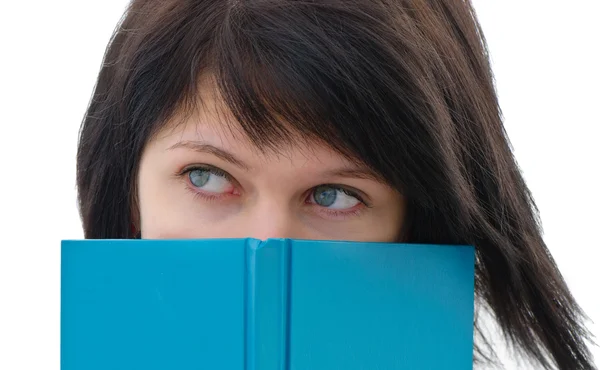 Close-up van een vrouw gluren over rand van boek — Stockfoto