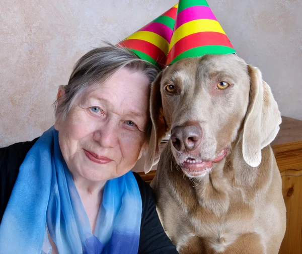 Kvinna och hund med partyhattar — Stockfoto