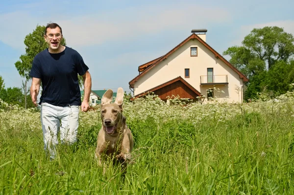 Uomo e cane che corrono all'aperto — Foto Stock