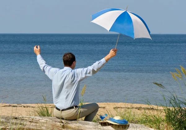 Hombre feliz con paraguas en la costa — Foto de Stock
