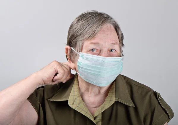 Senior kvinde iført beskyttende maske - Stock-foto