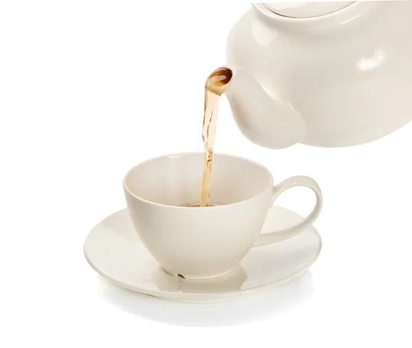 Té que se vierte en una taza de té aislada sobre un fondo blanco —  Fotos de Stock