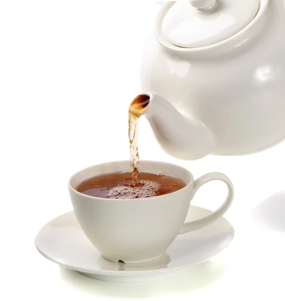 Thé versé dans une tasse de thé isolé sur un fond blanc — Photo