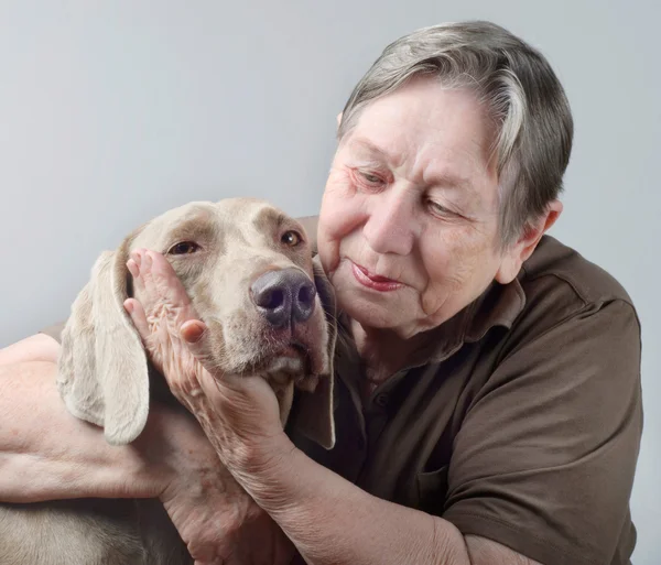 Äldre kvinna kramas och tröstande hund — Stockfoto