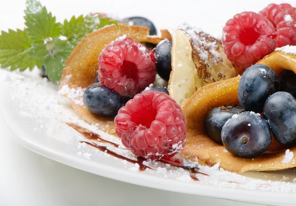 Pancakes topped with blueberries,raspberries, mint and powdered — Stock Photo, Image