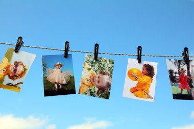 Photos are hanging against blue sky clipart