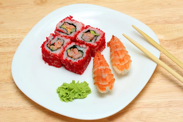 Rolos e sushi na placa — Fotografia de Stock