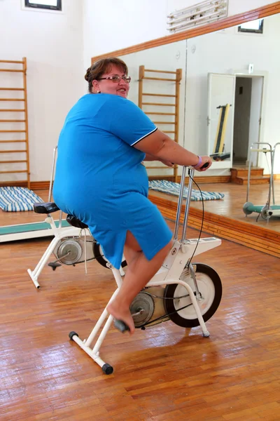 Túlsúlyos nő gyakorló kerékpár — Stock Fotó