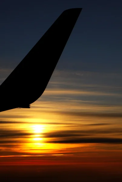 Sunrise over clouds with contour of airplane — Stock Photo, Image