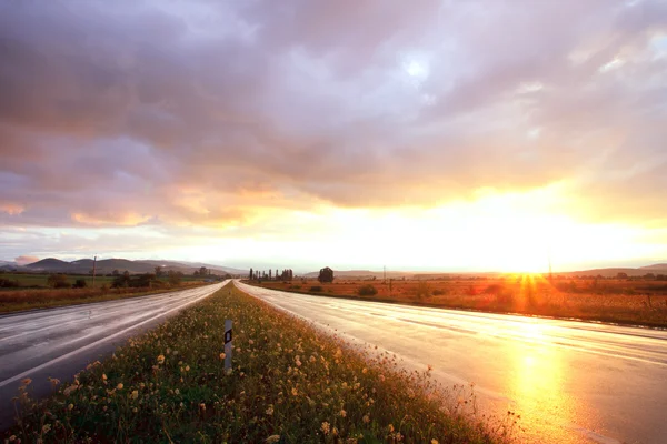 Sunset on wet road — Stock Photo, Image
