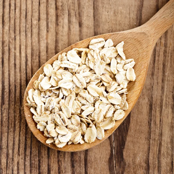 Oat flakes in spoon — Stock Photo, Image
