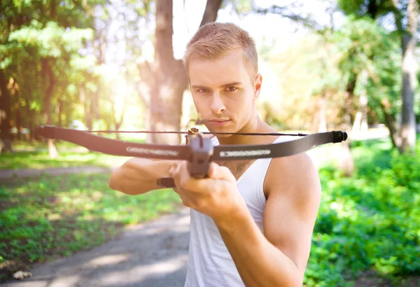 Strong young men with arbalest — Stock Photo, Image