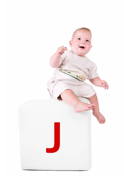 Маленька дитина на блоці з літерою — стокове фото