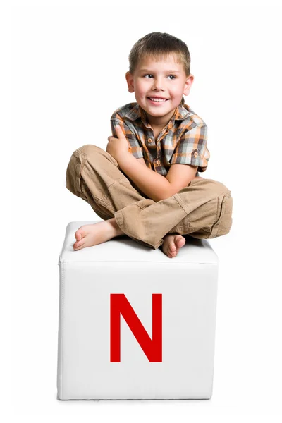 Malé dítě na bloku s písmenem — Stockfoto