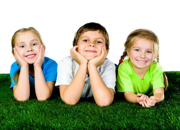 Niño y niñas acostados en una hierba verde —  Fotos de Stock