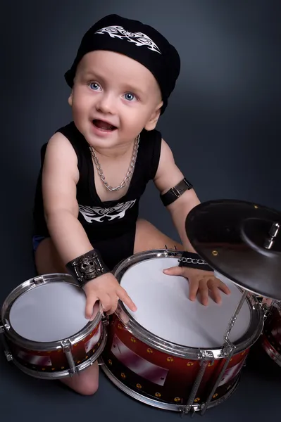 Красивый мальчик играет на барабанах — стоковое фото