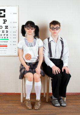 Two person wearing spectacles in an office at the doctor clipart