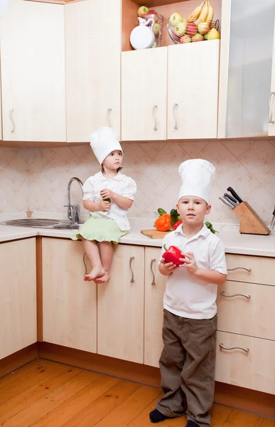 Small children on kitchen help to make a dinner