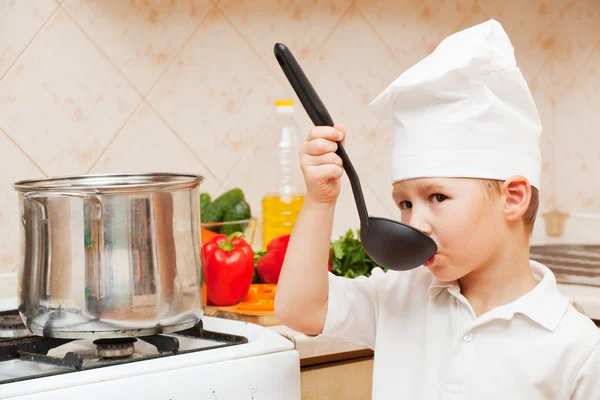 Little boy on kitchen helps to make a dinner
