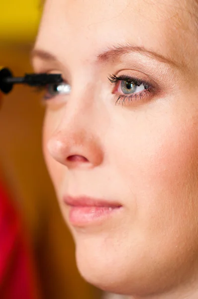 Woman is applying mascara — Stock Photo, Image