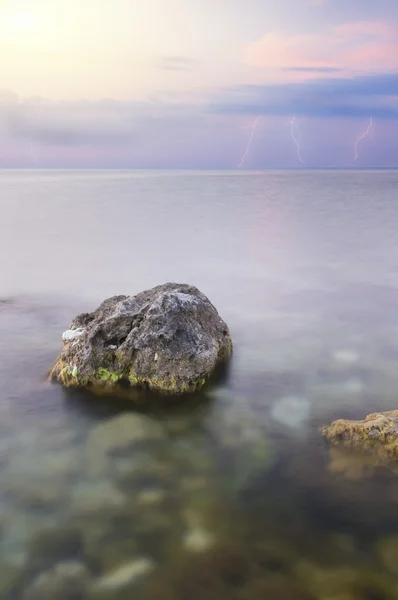 stock image Rock in ocean on sunset.