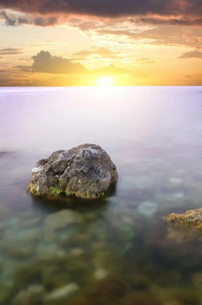 Moře a rock na západ slunce. — Stock fotografie