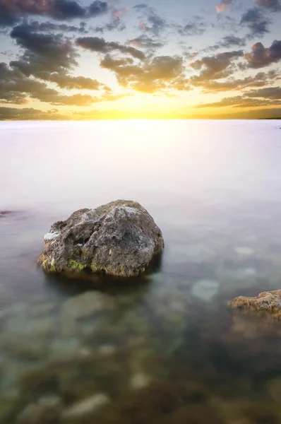 Moře a rock na západ slunce. — Stock fotografie