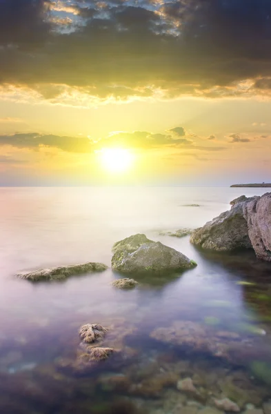 Скеля в морі на заході сонця . — стокове фото
